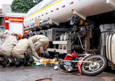 Motociclista para sob carreta e roda passa por cima de perna